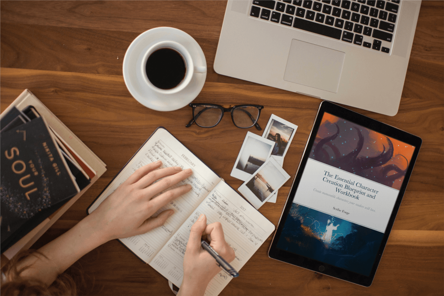 The Essential Character Creation Blueprint and Workbook on a tablet on a tabletop next to a person writing in a notebook.
